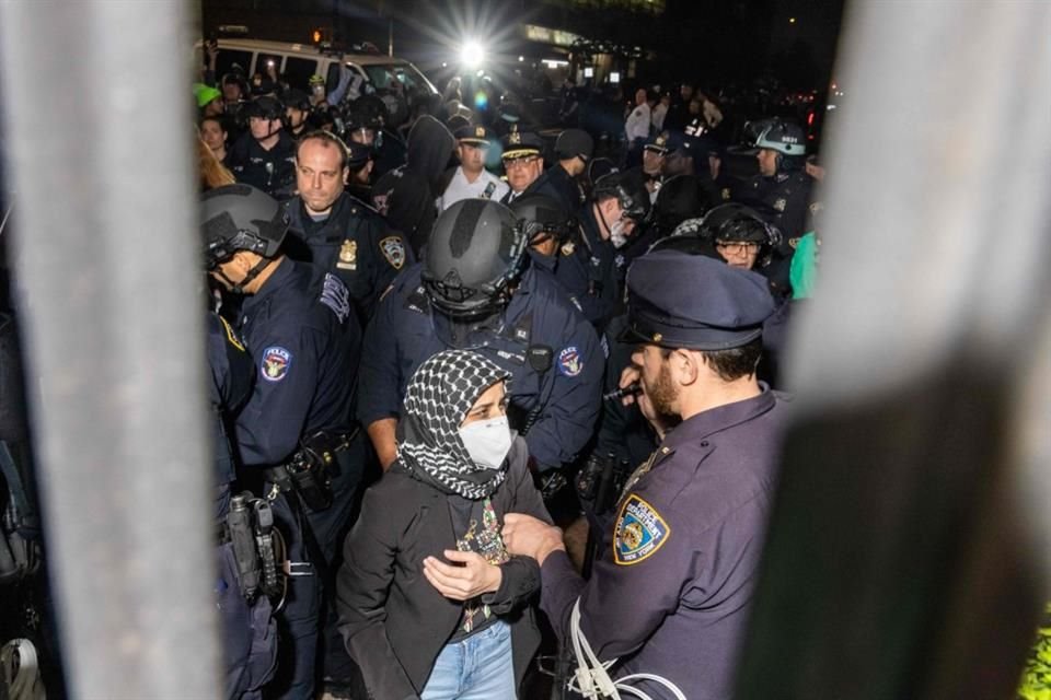 Miembros de la Policía de Nueva York arrestan a manifestantes que bloquean la entrada de la Universidad de Columbia.