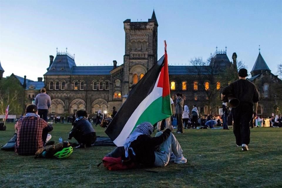 Un manifestante sostiene una bandera palestina dentro de un campamento en el campus de la Universidad de Toronto.