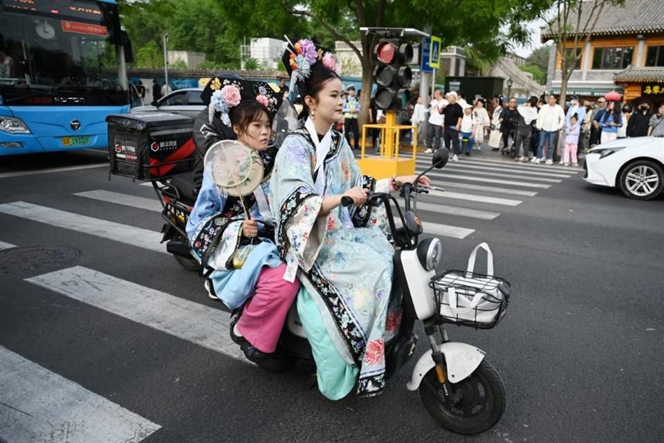 Dos mujeres viajan en un scooter eléctrico en las calles de Beijing el 4 de mayo del 2024.