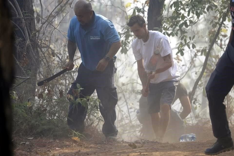 Vecinos de la zona, soldados, policías brigadistas y bomberos acudieron para elaborar brechas cortafuego para inhibir el avance del desastre.