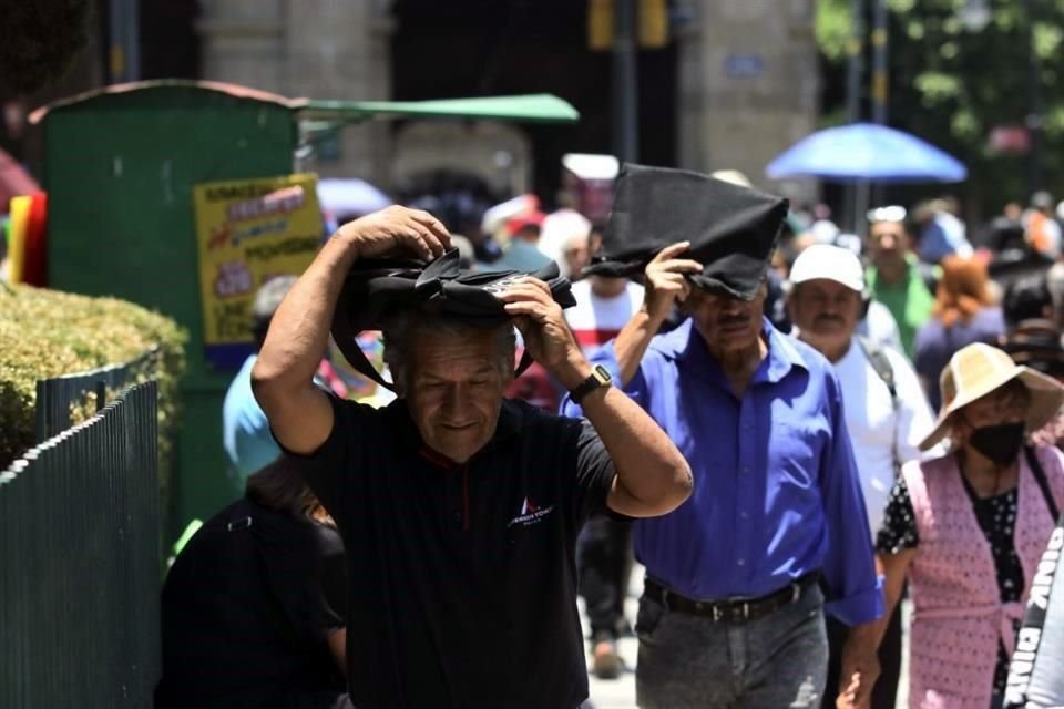 En el Centro Histórico, peatones se cubrieron con sombrillas, sombreros y hasta portafolios.