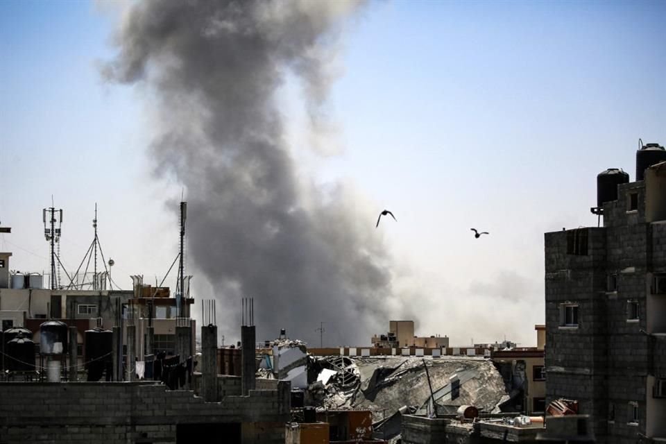 Humo se alza por encima de edificios tras un bombardeo israelí en Rafah.