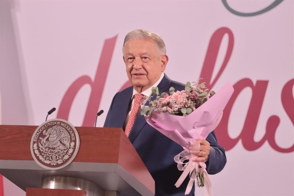 El Presidente felicitó a las madres con un ramo de flores en mano.