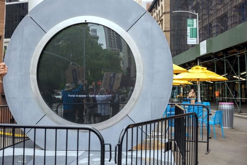 La gente pasa por una instalación de arte en video 'Portal' que conecta la ciudad de Nueva York y Dublín, Irlanda, a través de una transmisión de video en vivo las 24 horas, los 7 días de la semana.