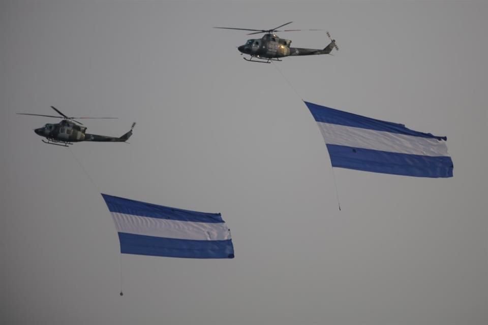 Helicópteros de la Fuerza Aérea Salvadoreña volando con banderas de El Salvador, durante la celebración del Bicentenario de la Fuerza Armada, el 5 mayo del 2024.