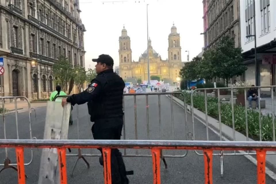 Un policía capitalino resguarda el acceso al Zócalo, donde la bandera nacional no ha sido izada.
