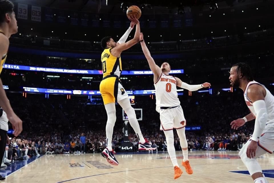 Donte DiVincenzo, el mejor anotador de los Knicks, intenta detener un tiro de Tyrese Haliburton, el mejor encestador de los Pacers, pero sin éxito.