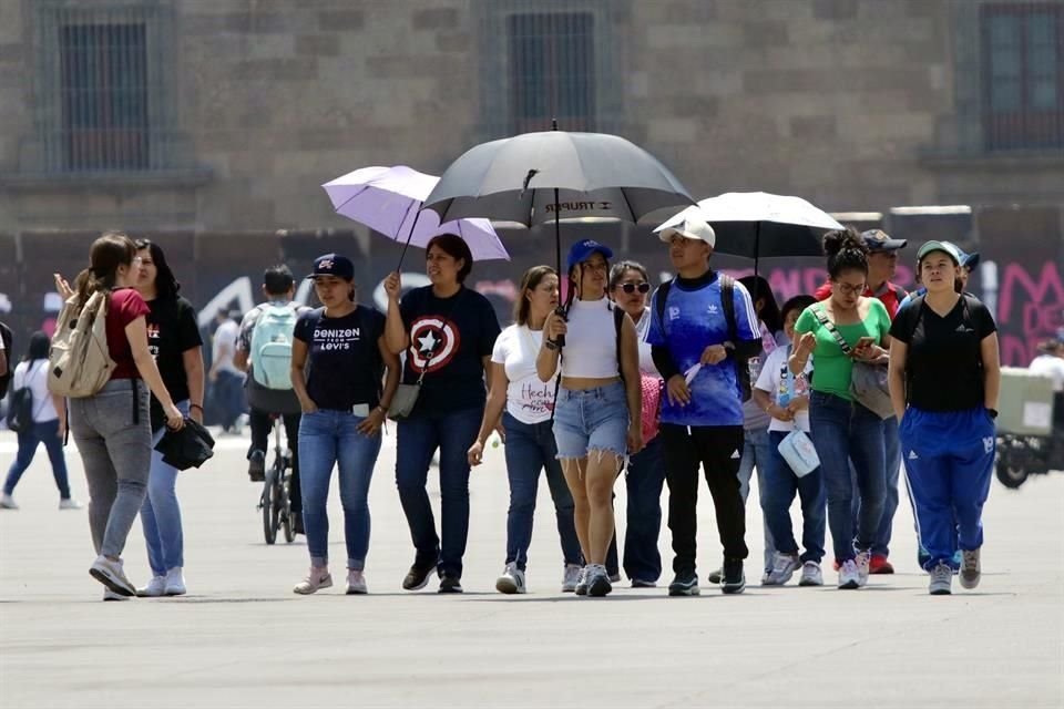 En el Centro Histórico, capitalinos se protegen con sombrillas.