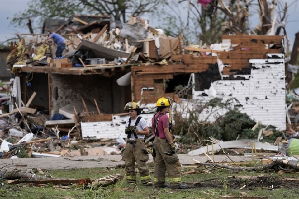 Bomberos observan los escombros de casas destrozadas en Greenfield, Iowa.