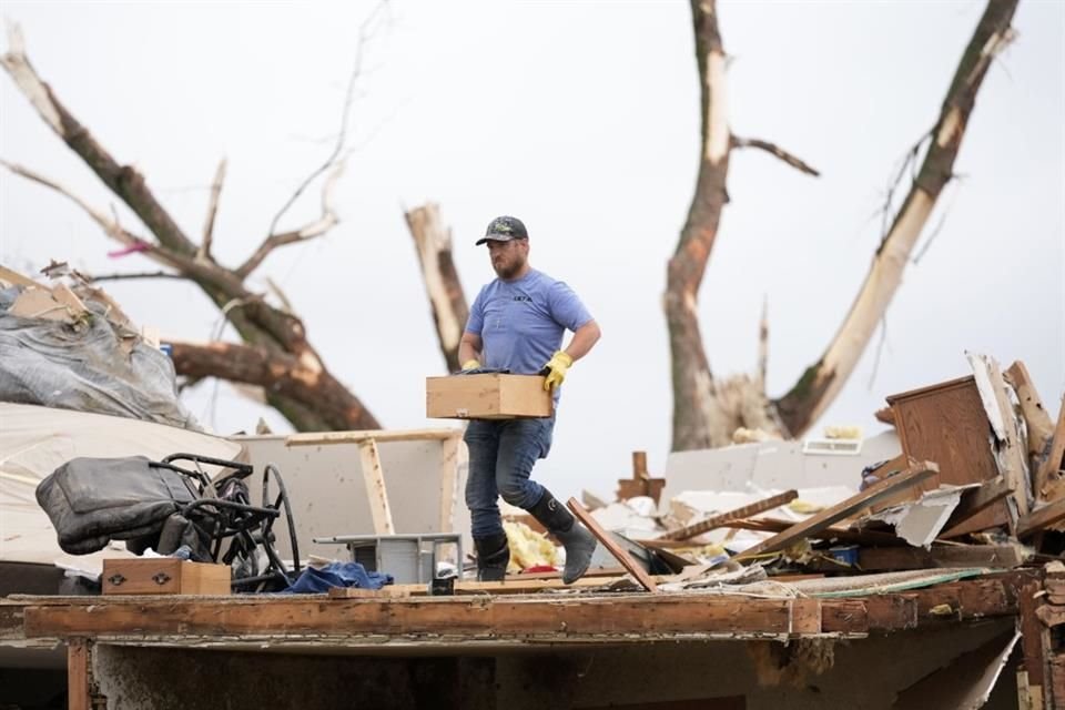 Un hombre busca entre los escombros de una casa dañada por un tornado el 21 de mayo del 2024.