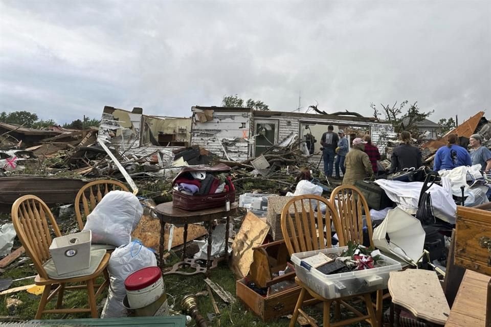 Personas examinan el daño dejado por un tornado en el pueblo de Greenfield, Iowa.