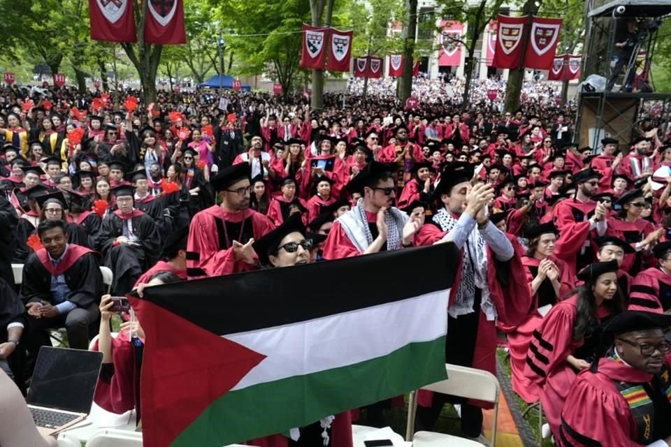 Un estudiante sostiene la bandera de Palestina mientras que 13 estudiantes son reconocidos por un orador estudiantil durante la ceremonia de graduación en Harvard.