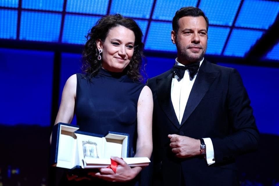 La directora francesa Coralie Fargeat posa en el escenario junto al actor francés Laurent Lafitte después de recibir el premio al Mejor Guión por la película 'La Sustancia'.