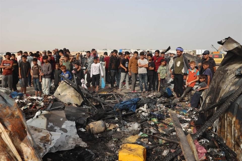 Palestinos observan los escombros de un bombardeo israelí en un campamento de refugiados en Rafah.