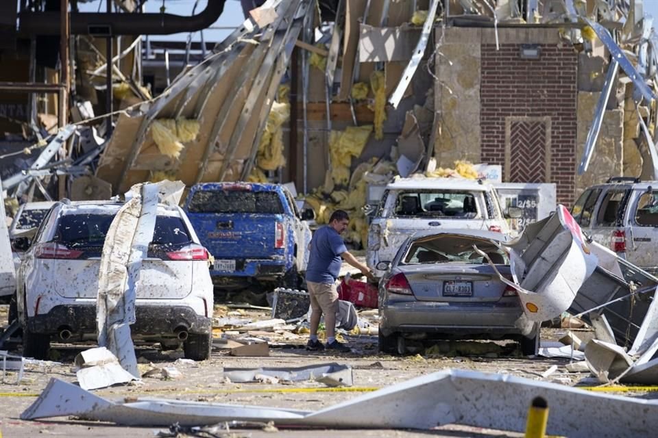 Un hombre mira a un auto dañado después de que un tornado pasara el día anterior el domingo 26 de mayo de 2024 en Valley View, Texas.