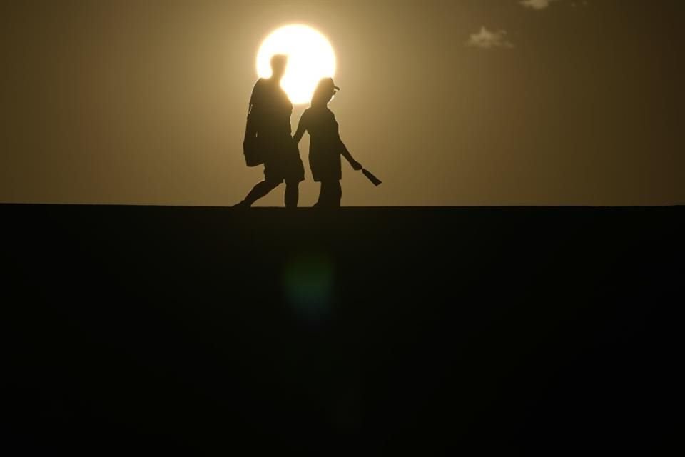 Personas caminan bajo el rayo del sol en el Parque Nacional Death Valley, en California, el 16 de julio del 2023.
