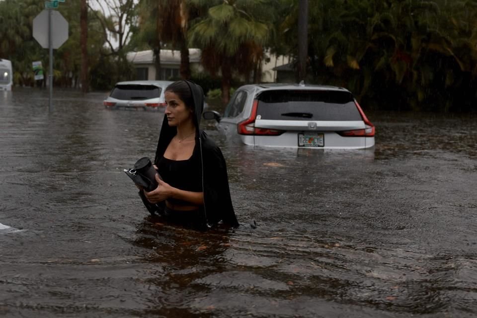 Una persona camina a través de una calle inundada en Hollywood, Florida.