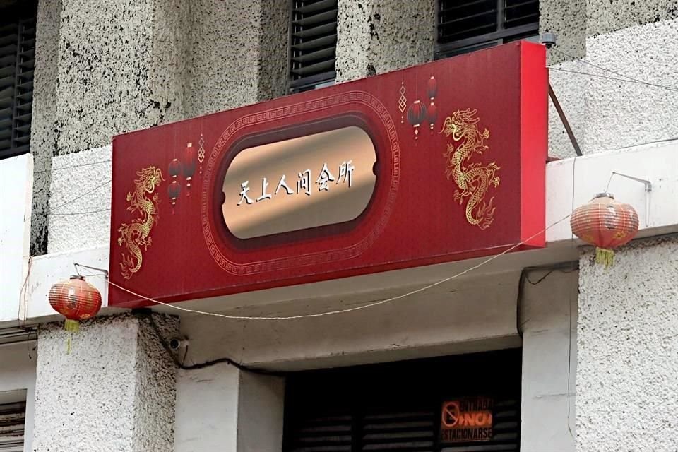 La entrada al 115 es por una puerta negra que tiene en su parte superior un letrero de letras doradas sobre fondo rojo escrito en chino: Cielo y Tierra.