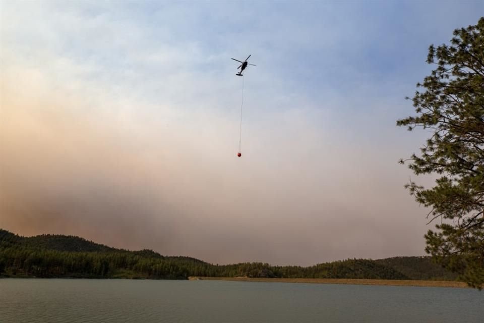 Un helicóptero recolecta agua del lago Mescalero mientras autoridades luchan por apagar incendios forestales en Nuevo México.