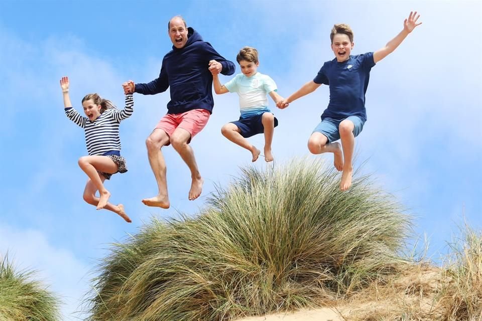 Se observa al primogénito del rey Carlos III saltando en el aire con sus tres hijos, durante un viaje a la playa.
