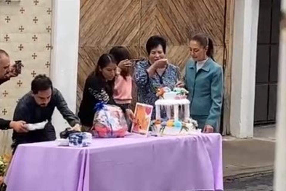 Claudia Sheinbaum llegó a su casa de transición pasadas las 9:00 horas y, antes de entrar, se acercó a su 'mesa de regalos' para partir el pastel.