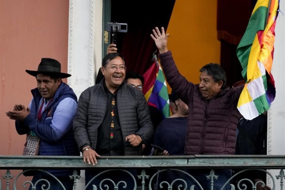 El Presidente boliviano, Luis Arce, en el centro, acompañado por el Vicepresidente, David Choquehuanca, a la derecha, se presenta ante sus seguidores en un balcón del palacio de gobierno.