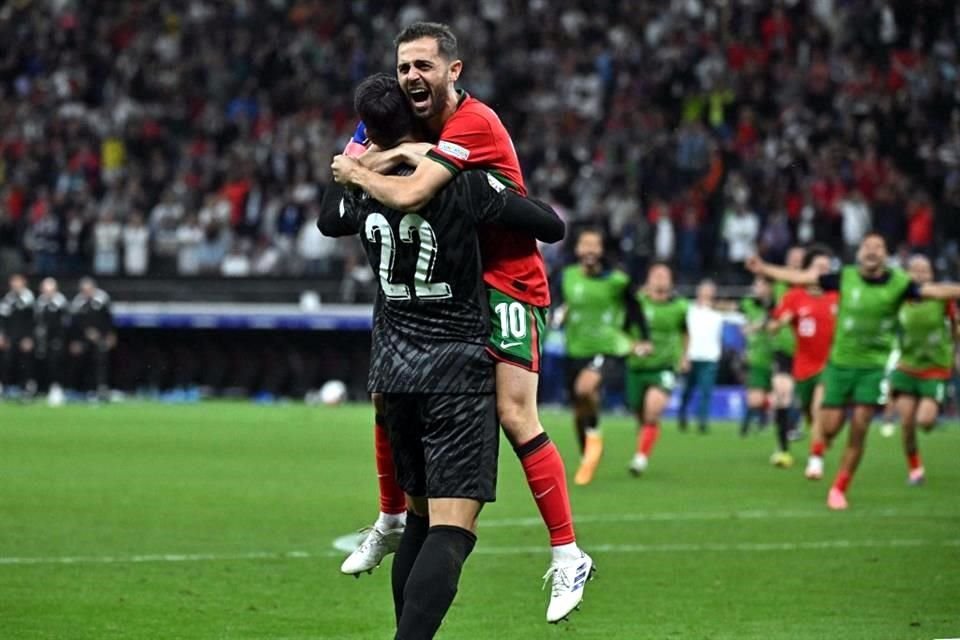 El arquero Diogo Costa (22) es felicitado por Bernardo Silva, tras la serie de penaltis ante Eslovenia.