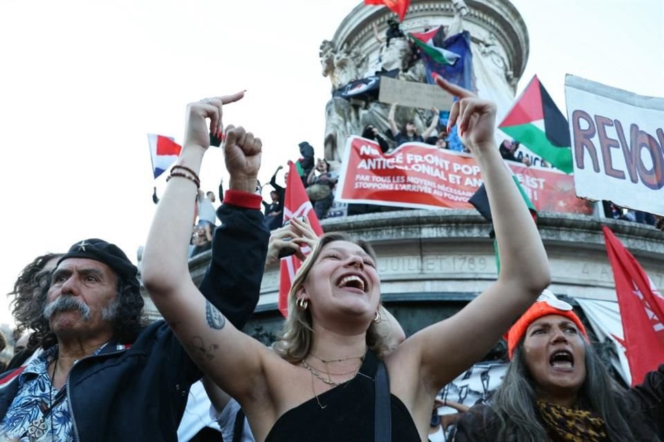 Personas celebran tras darse a conocer las estimaciones de la elección legislativa en Francia.