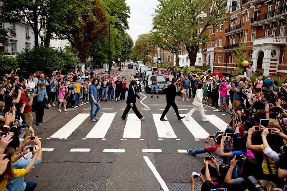 Personas caminan afueran de los estudios Abbey Road.