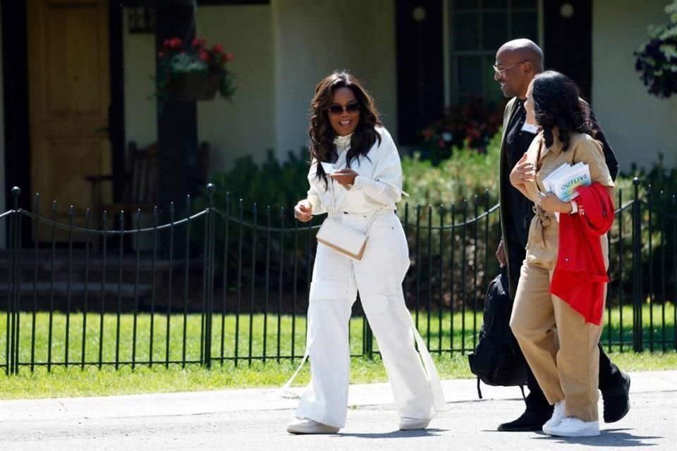 Oprah Winfrey, junto a Van Jones, sale de la conferencia.