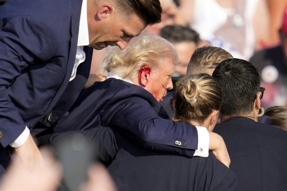 El candidato presidencial republicano, el ex Presidente Donald Trump, recibe ayuda para bajar del escenario en un evento de campaña en Butler.