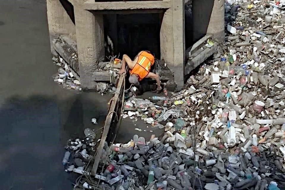 LIMPIEZA. Personal de la Comisión Nacional del Agua realiza trabajos para despejar el drenaje tapado por basura.