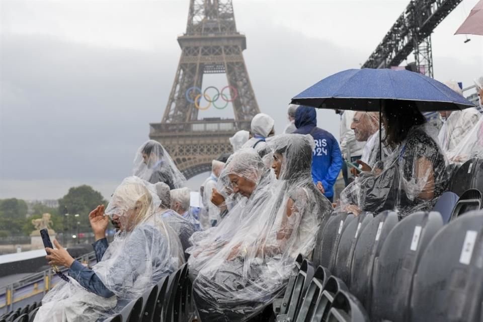 Los asistentes sacaron impermeables, paraguas y plásticos para protegerse de la lluvia.