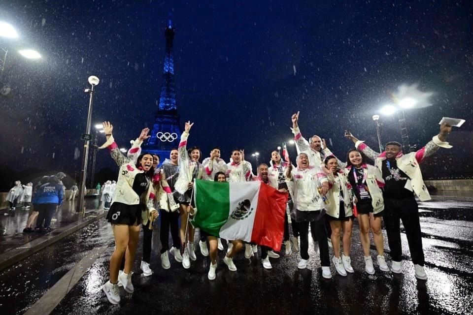 Sin importar el aguacero, la delegación mexicana posó con la bandera nacional en Trocadero, con la Torre Eiffel en el fondo.