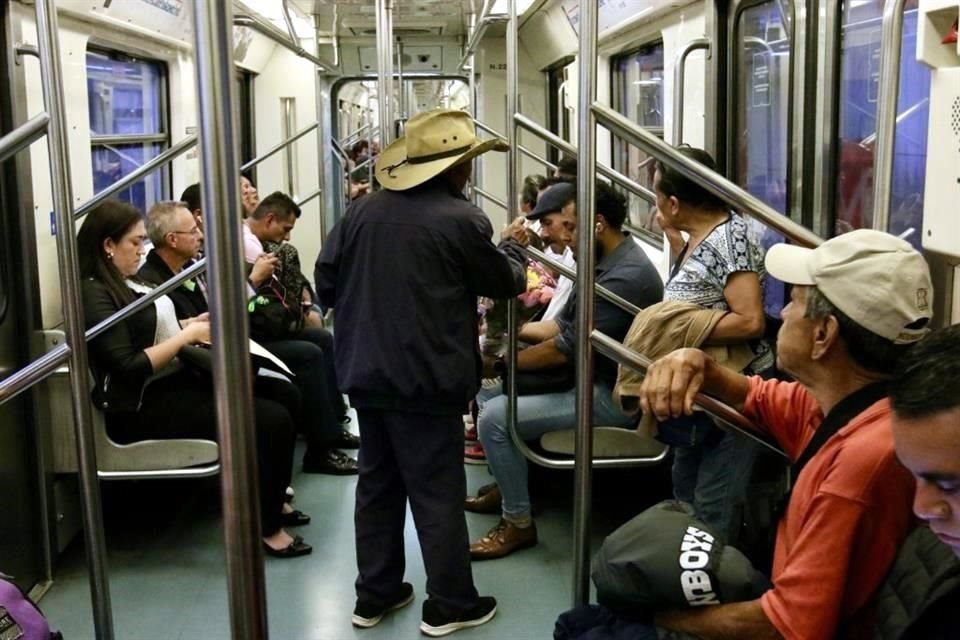 En el Metro, un hombre escucha música mientras ocupa un asiento reservado, pese a que un adulto mayor está frente a él.