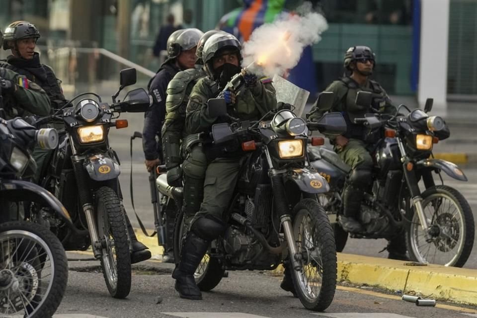 Policías disparan gas lacrimógeno a una protesta en Caracas.