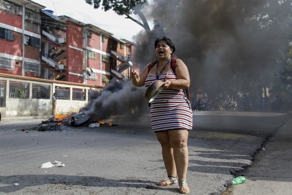 Una mujer golpea una cacerola durante una protesta contra el resultado de la elección venezolana en Caracas.