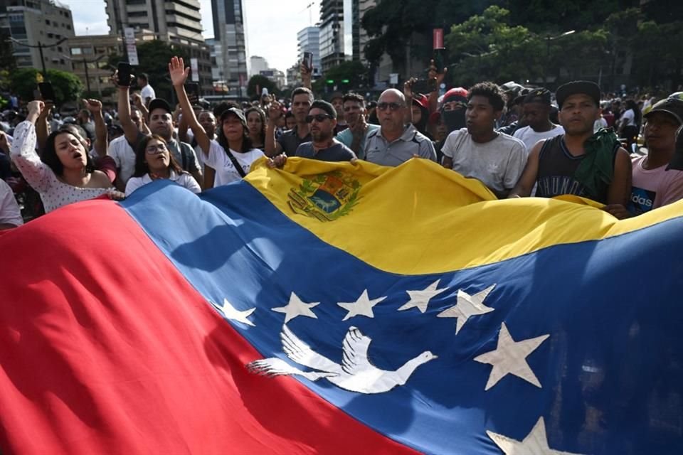 Manifestantes venezolanos sostienen una bandera durante una protesta en Caracas.