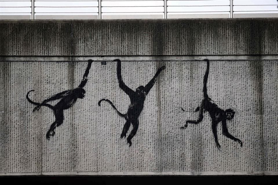 El miércoles Banksy reveló tres monos que se balancean desde un puente ferroviario en Shoreditch, una de las zonas de moda en Londres.