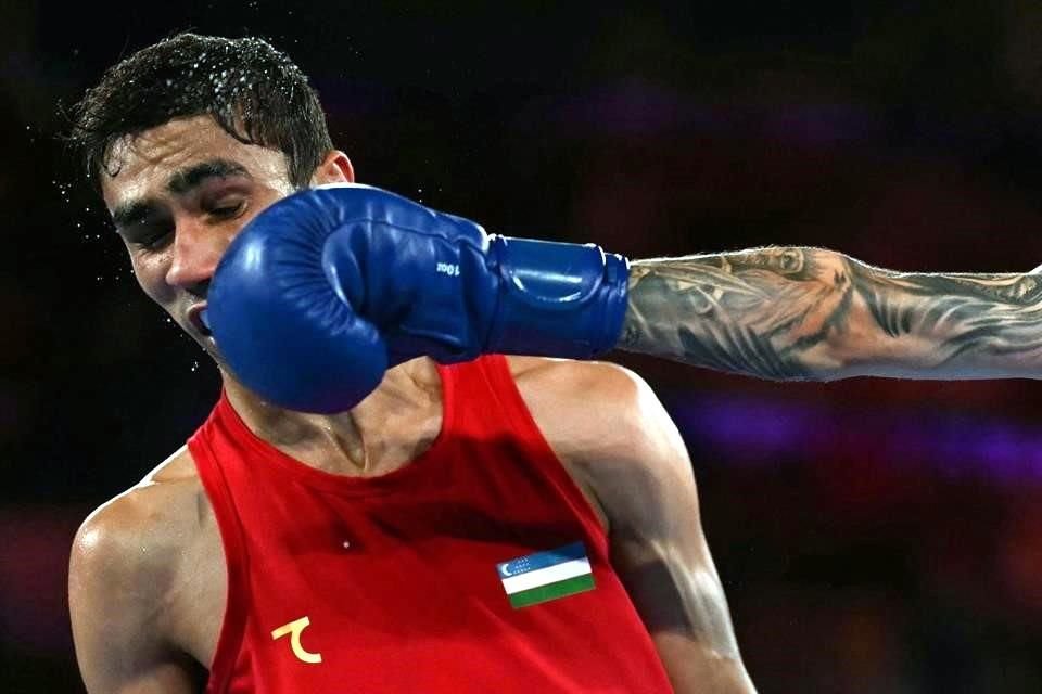 Charlie Senior (aguante azul), de Australia, conecta la cara de Abdumalik Khalokov, de Uzbekistán, en combate de la Semifinal de boxeo de 57kg masculino; Khalokov avanzó a la Final.