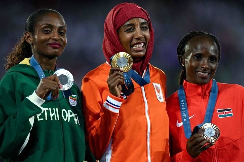 La medallista de Plata, la etíope Tigst Assefa (izq.), la medallista de Oro, la neerlandesa Sifan Hassan, y la medallista de Bronce, la keniana Hellen Obiri, en la premiación del maratón femenil.