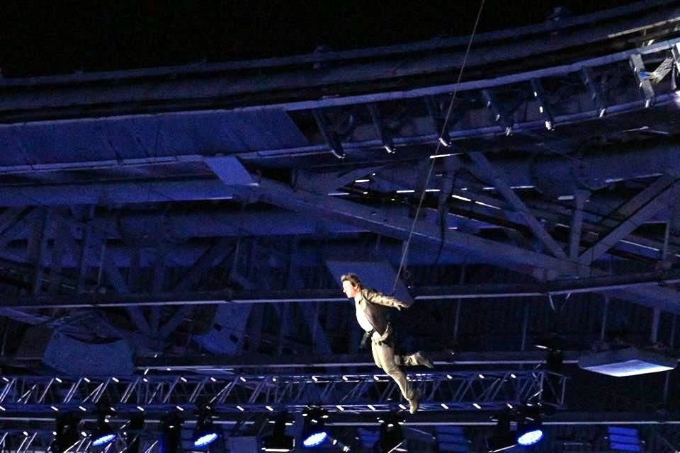 El actor estadounidense Tom Cruise desciende del techo del Stade de France, como parte de la Ceremonia de Clausura.