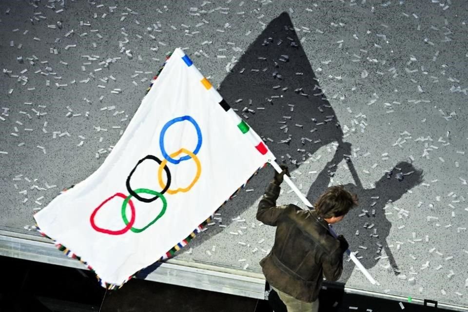 Como parte de una 'misión imposible', Tom Cruise, de manera dramatizada, lleva la bandera olímpica hacia la sede de los próximos Juegos Olímpicos, Los Ángeles, California.