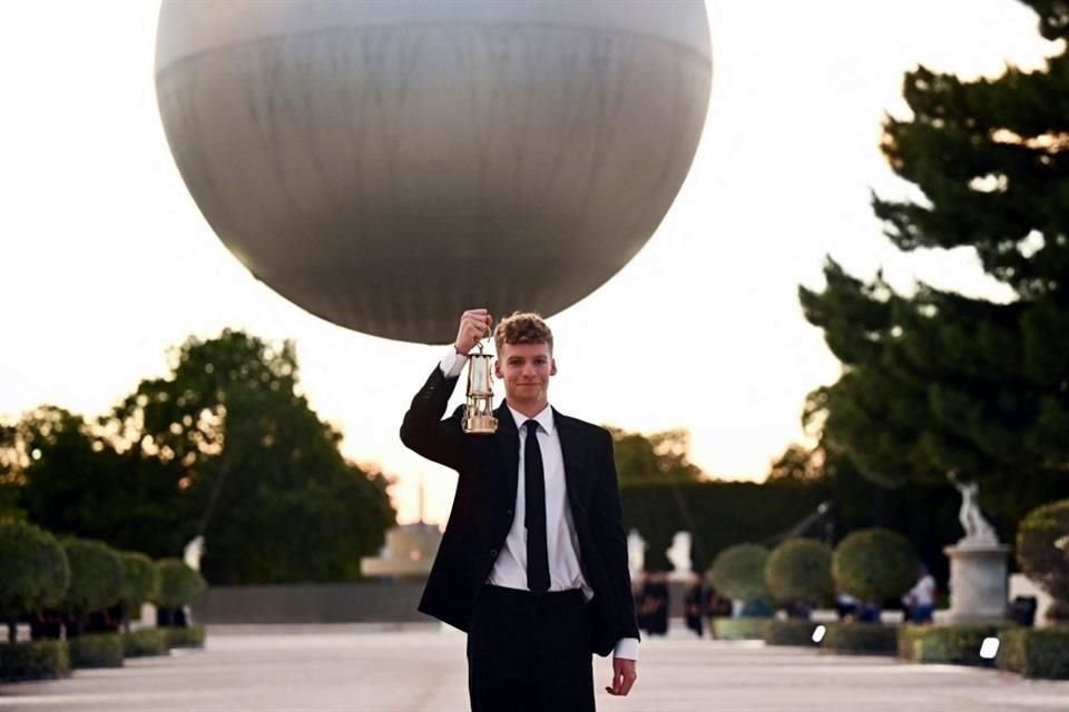 El nadador francés Leon Marchand recoge la llama olímpica del pebetero, antes de la ceremonia de clausura de los Juegos Olímpicos de París 2024 en el Jardín de las Tullerías, en París.