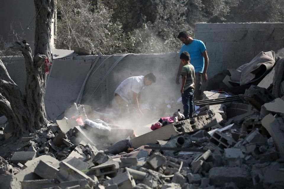 Miembros de una familia buscan entre los escombros tras un ataque israelí en la Franja de Gaza.