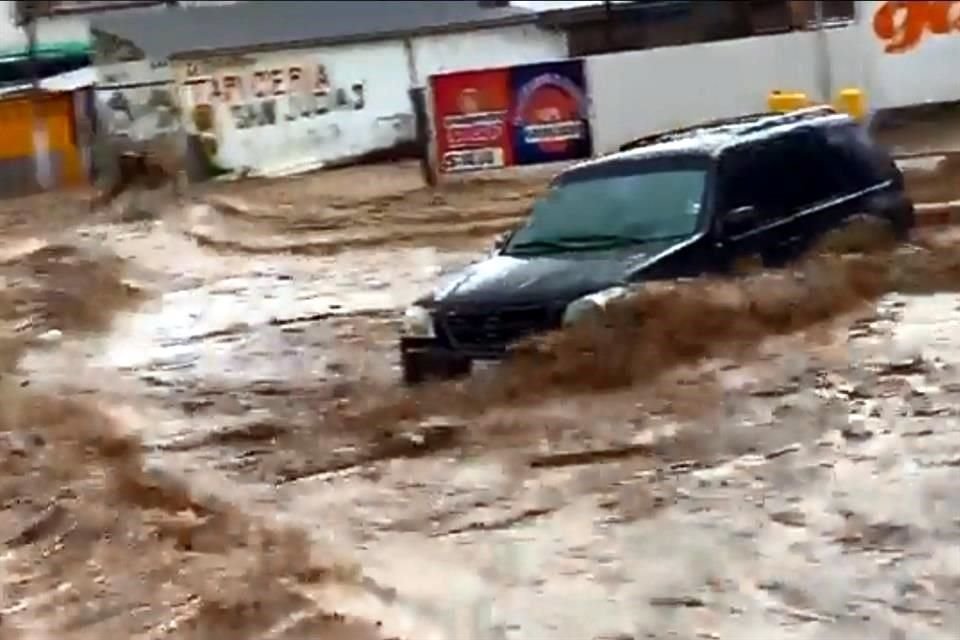Cuerpos de emergencia revisan autos arrastrados para descartar víctimas.