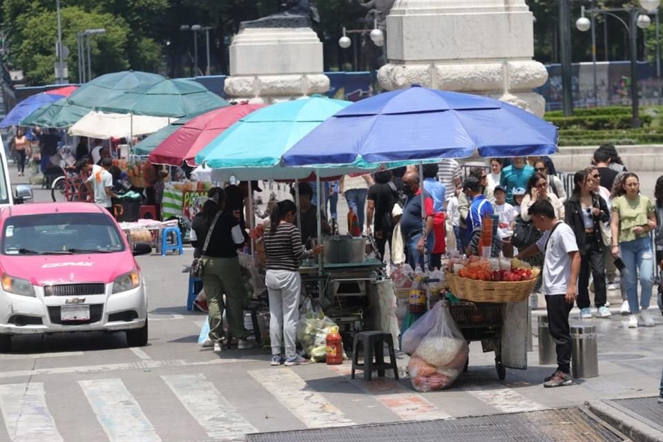 Tras la instalación de un cerco en la Alameda Central, comerciantes informales tomaron parte de Avenida Juárez para colocar sus puestos.