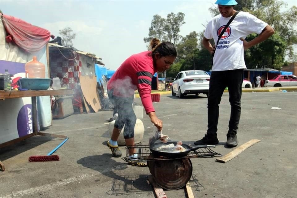 Las cocinas también se improvisan. Migrantes usan maderas y botes para prender fuego.