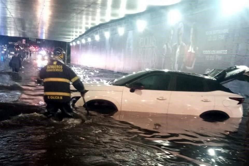 Bomberos ayudaron a liberar un auto que quedó sumergido por las inundaciones.