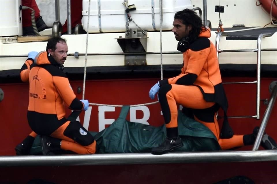 Los buzos de los bomberos italianos traen a tierra en una bolsa verde el cuerpo de una de las víctimas del buque de bandera británica Bayesia.